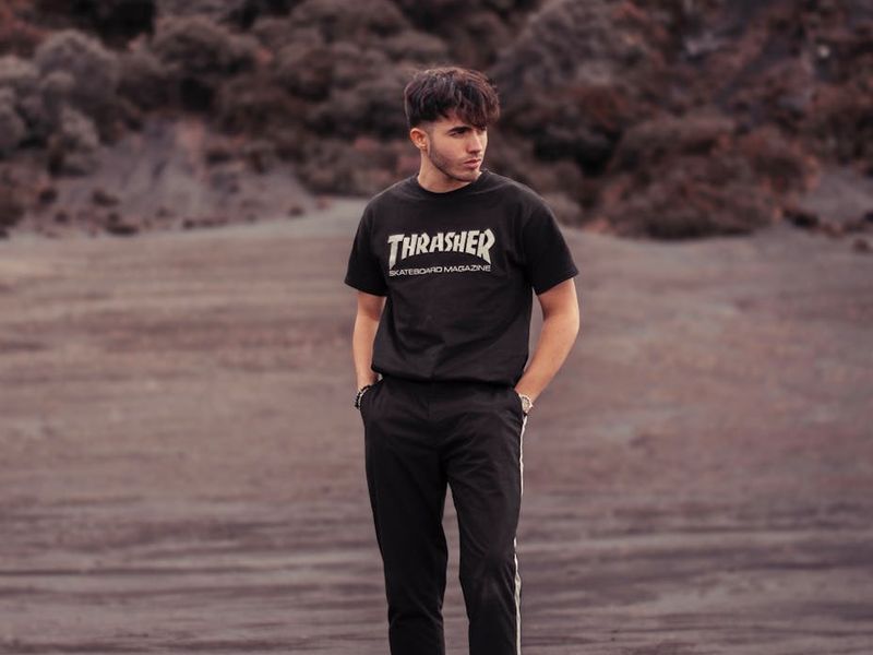 Man in a dynamic athletic pose against a dark background.